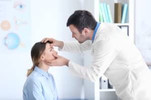 A doctor examining a patient for symptoms of corneal disease